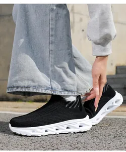 Détail de baskets en maille noire avec semelle amortissante évidée sur asphalte