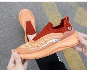 Detail van ademend oranje mesh bovenwerk en elastische kraag op de wandelschoenen