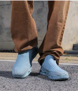Gros plan de baskets de course en tricot bleu clair sur asphalte pour le sport