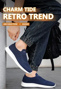 Detailopname van marineblauwe gebreide slip-on sneakers gedragen met een spijkerbroek