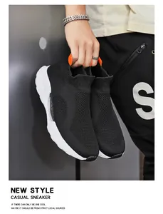Detail eines leichten schwarzen Strick-Sneakers mit orangefarbener Schlaufe und weißer Sohle