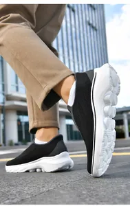 Macro detail of breathable black knitted fabric and white cushioned sole on men's walking shoes
