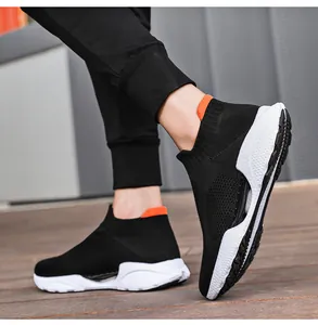 Nahaufnahme von schwarzem Strick-Sneaker mit orangefarbenem Fersenakzent und weißer Sohle