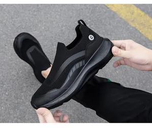 Detailopname van flexibele zwarte mesh slip-on sneakers met dikke antislip rubberen zolen