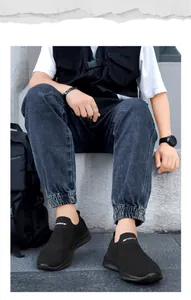 Buitenfoto van zwarte slip-on mesh sneakers met wit SPORTS-logo en ademende stof voor buiten
