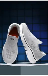 Dettaglio della tomaia in maglia grigia traspirante e suola a onde delle sneakers