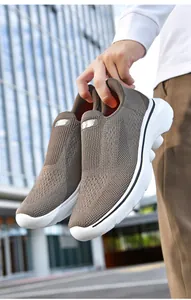 Detail of dark brown slip-on walking shoe with breathable mesh and white athletic sole