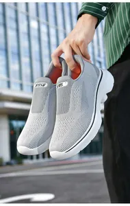 Outdoor shot of light gray slip-on walking shoes with breathable knit and white thick soles