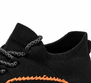 Detail von atmungsaktivem Fly-Knit-Gewebe und orangefarbenen Stickereien auf Sportschuhen