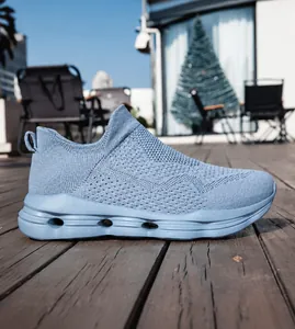 Detail view of light blue breathable knitted mesh sneakers on a wooden terrace background