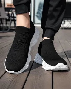 Detailed view of breathable black knit sock sneakers with white thick wavy outsoles