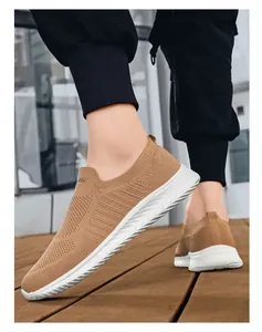 Detail van ademende kaki gebreide instappers met slipvaste witte gekartelde zolen