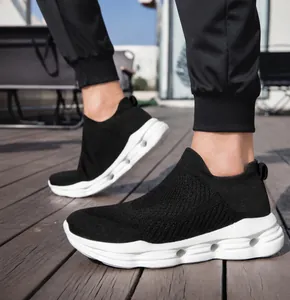 On-foot view of black breathable knit slip-on sneakers with cushioned white soles