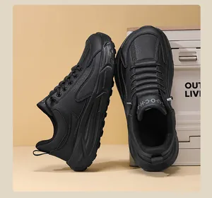 Detail view of black faux leather sports shoes with thick cushioning sole and UOCHA logo
