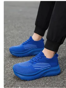 Nahaufnahme blauer Strick-Sneaker mit dicker strukturierter Sohle auf Asphalt