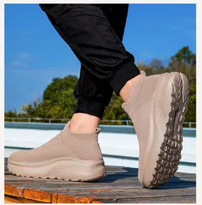 Khaki Strickschuhe zum Reinschlüpfen mit dicker Schaumstoffsohle auf Holzdeck im Freien