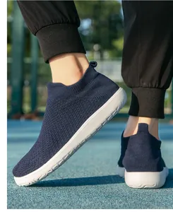 Baskets en tricot bleu marine pour hommes avec semelles blanches sur un terrain de sport