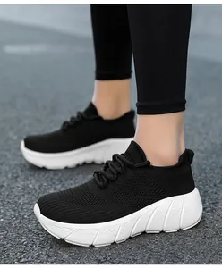 Dettaglio di scarpe da camminata nere traspiranti con suole bianche ammortizzate su asfalto