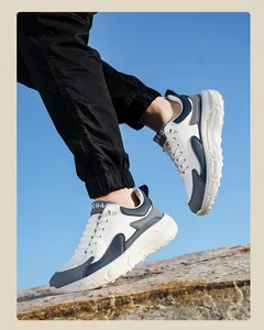 Close-up of tricolor patchwork leather sneakers with thick soles on rocky terrain