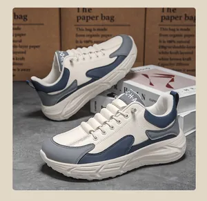 Detail of multi-material patchwork sneakers with chunky soles and navy accents