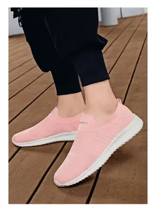 Detail van roze gebreide ademende instapsportschoen met witte antislip golvende zool