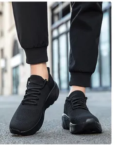 Dettaglio della tomaia in maglia nera traspirante e suola spessa della scarpa sportiva