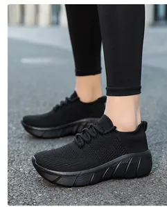 Vista esterna di sneakers in maglia nera traspirante con suole spesse strutturate