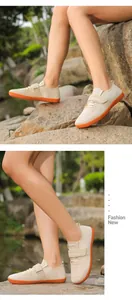 Detail view of beige training shoes with orange anti-slip sole and velcro strap