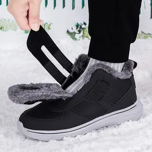 Bottes d'hiver imperméables fourrées noires avec fermeture velcro dans la neige
