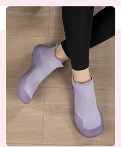 Dettaglio scarpa fitness in maglia lavanda con suola in gomma antiscivolo su legno