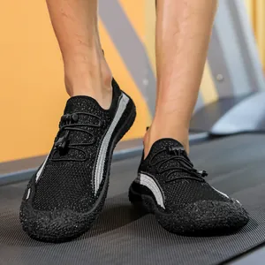 Gros plan de chaussures d'eau en maille noir et gris avec cordons de serrage sur tapis roulant