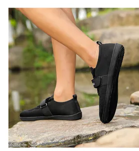 Outdoor shot of black knit training shoes with velcro straps on a rocky surface