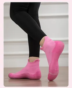 Dettaglio scarpe da yoga in maglia rosa con suola antiscivolo indossate da modella