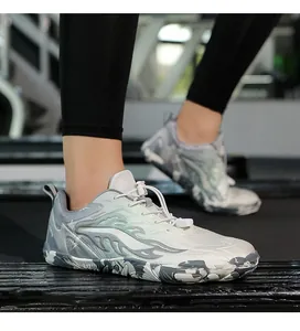 Photo d'action de chaussures pieds nus grises avec motifs flammes sur tapis de course