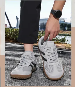 Détail de baskets grises avec deux bandes noires et semelle en caoutchouc marron durable