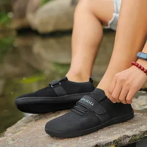 Outdoor shot of black breathable mesh athletic training shoes with velcro strap and thick sole