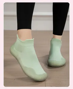 Dettaglio di scarpe da ginnastica in maglia verde chiaro con suola in gomma antiscivolo