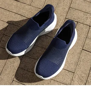 Dettaglio scarpa da camminata in maglia blu scuro con mesh traspirante e suola bianca spessa
