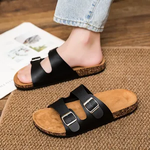 Klassische schwarze Doppelbuckle-Korkhausschuhe für Damen und Herren auf Holzboden
