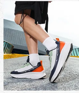 Detail view of breathable wide-toe sneakers featuring orange and navy accents on pavement