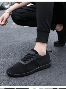 Close-up of black breathable mesh fabric and lace-up details on casual sneakers