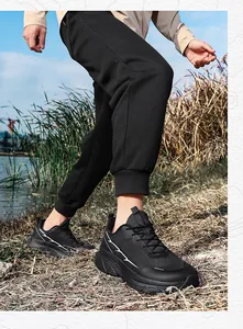 Outdoor close-up of men's wide-fit breathable mesh running shoes on grassy riverbank