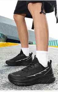 Outdoor shot showing side view of breathable black mesh running sneakers with white details