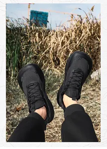 Detail of black wide-toe trail running shoes with breathable mesh and quick-lace system