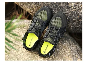 Close-up of breathable mesh men's hiking shoe with bungee laces on a natural rock