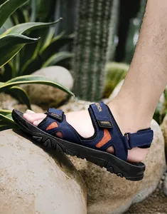 Outdoor men's beach sandals with navy straps and non-slip rubber soles in desert setting
