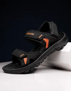 Detail of black sports sandals featuring orange mesh panels and adjustable velcro straps