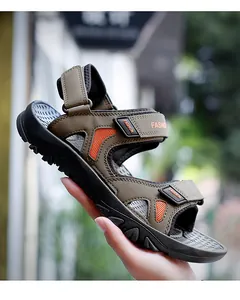 Detail of khaki men's sports sandal with velcro strap and orange mesh accents