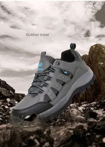 Detail of grey outdoor hiking boots with MD sole and blue accents on a rocky background