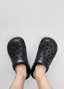 Close-up of black breathable garden clogs showing dual-wear heel strap and air-cushioned sole